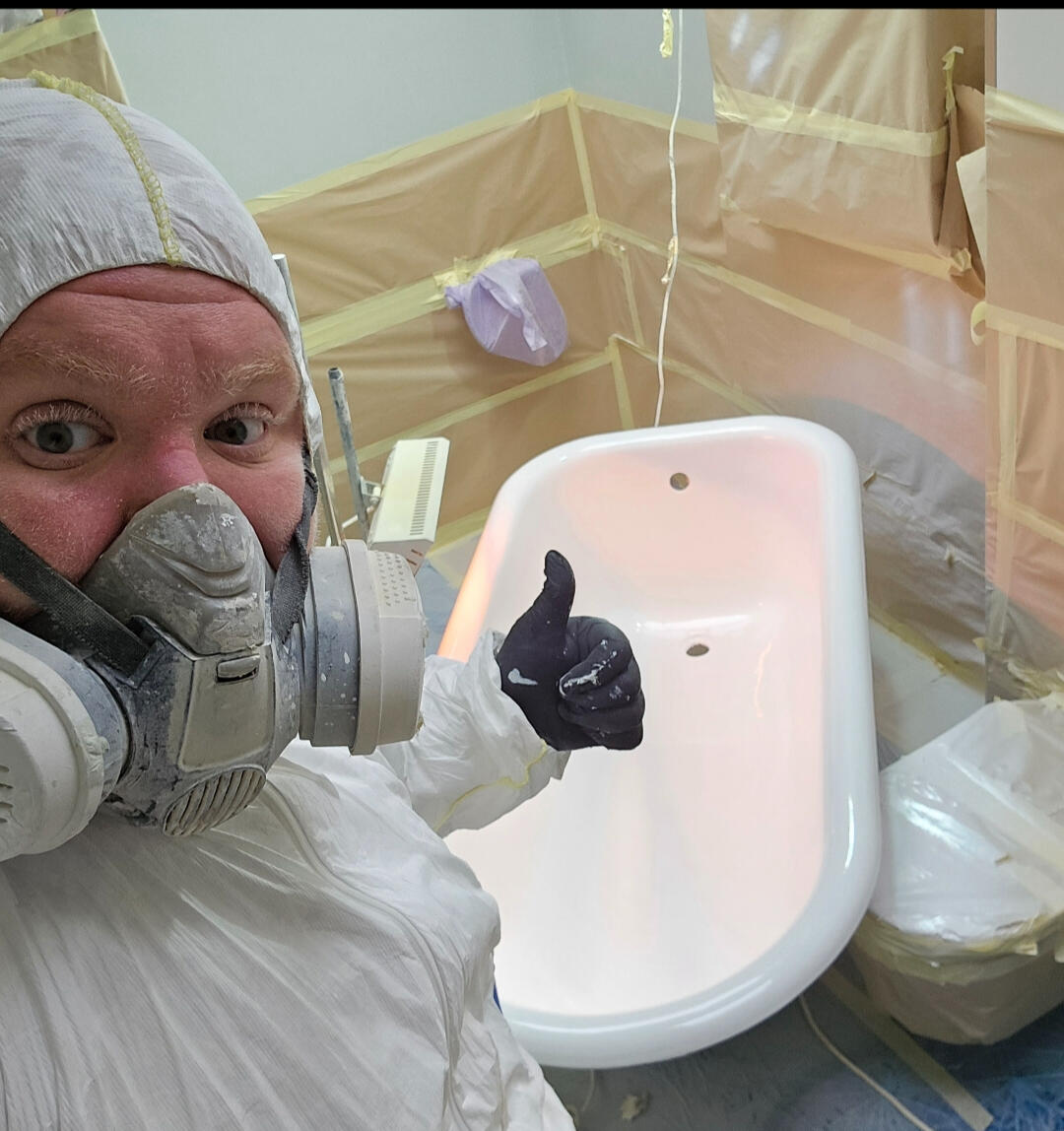 photo of glossy baths owner photo of glossy baths re-enamelling owner Seamus with a thumbs up, in ppe, in a room full of masking up and a completed bath in Salisbury